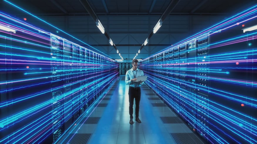 An IT technical engineer with a laptop in the data server room.